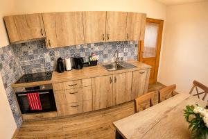 a kitchen with wooden cabinets and a sink and a table at Apartmány Lipno 46 in Lipno nad Vltavou +14 photos