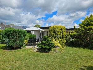 a backyard with a table and a white umbrella at Modern, spacious villa with Sauna in Ruds-Vedby