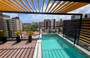 a balcony with a swimming pool on top of a building at Solon Flat Manaira in João Pessoa