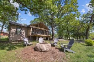a log home with chairs and a fire pit at Serenity - 60 Ridge Lane in Branson
