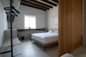 a bedroom with a white bed and a window at Zahir Rooms & Wellness srls in Trapani