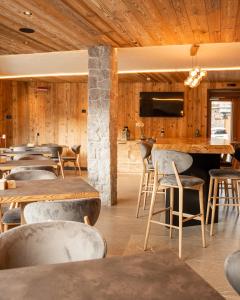 a restaurant with wooden walls and tables and chairs at Hotel Cristallo in Andalo