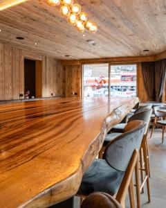 a large wooden table in a room with chairs at Hotel Cristallo in Andalo +234 photos