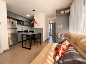 a living room with a couch and a kitchen at Solon Flat Manaira in João Pessoa