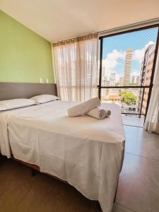 a bedroom with a large bed and a large window at Solon Flat Manaira in João Pessoa +15 photos