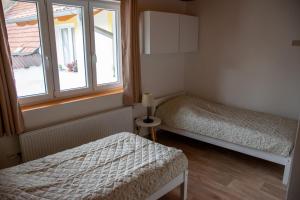 a bedroom with two beds and a window at Apartmán Cukrárna in Mladá Vožice