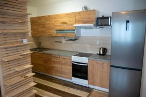 a kitchen with wooden cabinets and a refrigerator at Apartmán Cukrárna in Mladá Vožice