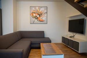 a living room with a couch and a flat screen tv at Apartmán Cukrárna in Mladá Vožice
