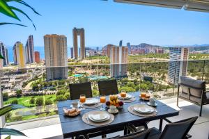 a dining table on a balcony with a view of the city at Skyline Infinity Apartment Eagle Tower Benidorm in Benidorm
