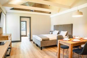 a hotel room with a bed and a table and chairs at Livonia Central Apartments in Valga