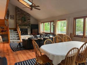 a living room with a table and chairs and a fireplace at Goose Hollow 19 Estates Pet Friendly Private Waterfront Home in Campton