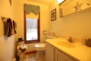a bathroom with a teddy bear standing next to a toilet at Goose Hollow 19 Estates Pet Friendly Private Waterfront Home in Campton +16 photos