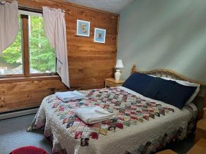 a bedroom with a bed with a quilt on it at Goose Hollow 19 Estates Pet Friendly Private Waterfront Home in Campton