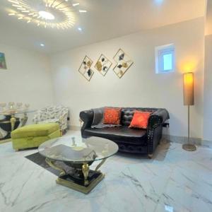 a living room with a black leather couch and a glass table at Heaven in Sutton