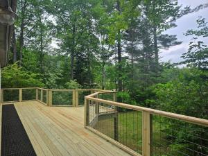 a wooden deck with a view of the woods at Goose Hollow 19 Estates Pet Friendly Private Waterfront Home in Campton