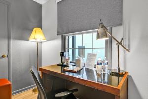 a room with a desk with a lamp and a window at Harvest Drive Family Inn - Renovated Rooms in Gordonville