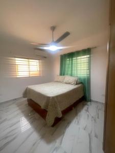 a bedroom with a bed and a ceiling fan at Las Tres Casitas in San Felipe de Puerto Plata