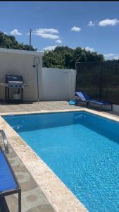 a swimming pool with blue water in a yard at Las Tres Casitas in San Felipe de Puerto Plata