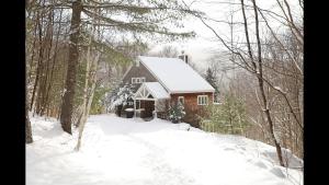 a cabin in the snow in the woods at Weetamoo Trail 50 Estates Relax in the White Mountains in Campton