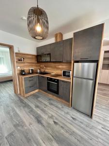 a kitchen with a stainless steel refrigerator and a chandelier at iHome Apartman 4 in Pécs