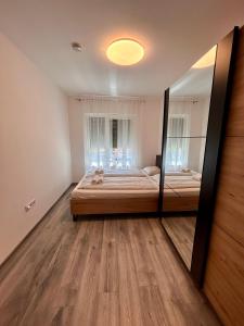 a bedroom with a bed and a large mirror at iHome Apartman 4 in Pécs