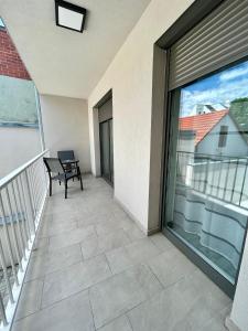 a balcony with a bench and a large window at iHome Apartman 4 in Pécs