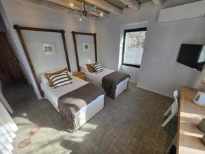 a bedroom with two beds and a television in it at Stipa Boutique Hotel in Chacras de Coria