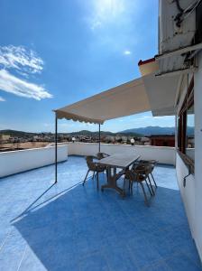 a patio with a table and chairs on a roof at Vila Vladmir Sela in Ksamil
