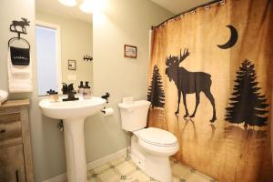 a bathroom with a toilet and a shower curtain with a deer at Bog Road 76 Campton Cozy Private Single Family Home in Campton in Campton +3 photos