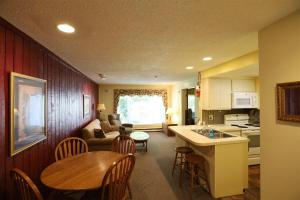 a kitchen and living room with a table and chairs at Inns of Waterville Valley 105 One Bedroom Garden Level Unit at Inns of WV in Waterville Valley