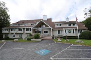 a large house with a parking lot in front of it at Inns of Waterville Valley 105 One Bedroom Garden Level Unit at Inns of WV in Waterville Valley