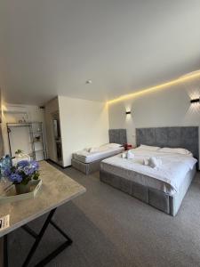 a hotel room with two beds and a table at Villa HOLM in Solotvyno