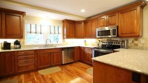 a kitchen with wooden cabinets and stainless steel appliances at Rising Ridge 28 Owls Nest Deluxe Pet friendly Home at Owl`s Nest in Campton