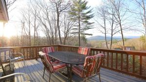 a table and chairs on a deck with a view at Rising Ridge 28 Owls Nest Deluxe Pet friendly Home at Owl`s Nest in Campton