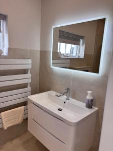 a bathroom with a white sink and a mirror at Luxury sea view villa in Ballycastle +16 photos