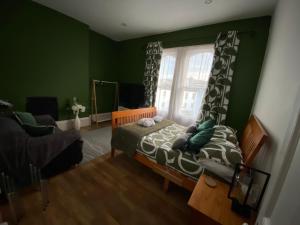 a bedroom with green walls and a bed with a window at City Centre Double Room in Truro