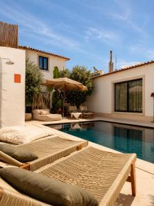 a swimming pool with two chaise lounges next to a house at A Casa Brava in Santarém