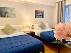a room with two beds with blue sheets and a flower at Hotel La Residence du Voyageur in Montreal