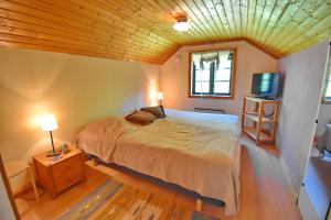 a bedroom with a bed with a wooden ceiling at "Tuna Sol" in Vimmerby