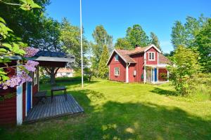 a yard with two houses and a wooden deck at "Tuna Sol" in Vimmerby