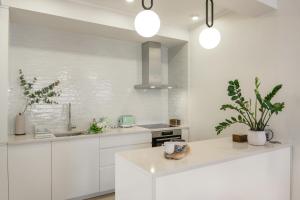 a kitchen with white cabinets and a counter with plants at Luxurious Bohemian Residence with Pool in Tivat