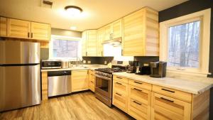 a kitchen with wooden cabinets and stainless steel appliances at Green Circle 29 Estates Pet Friendly Private Home in Waterville Estates in Campton