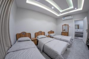 three beds in a room with a skylight at The view apartment 2 in Al Baha