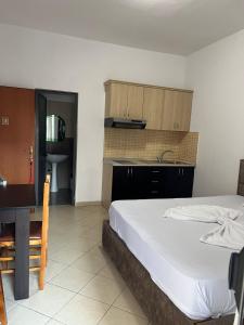 a bedroom with a large bed and a kitchen at Vila Mare in Shëngjin
