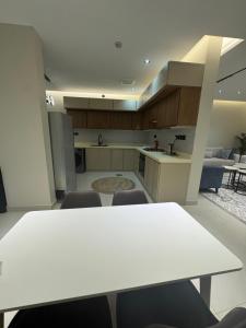 a kitchen with a white table and chairs in a room at شاليه لوسيندا 2 in Baljurashi