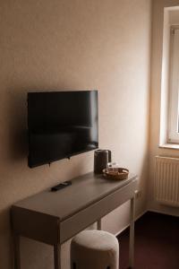 a room with a desk with a television on a wall at Pension Glück in Schleife