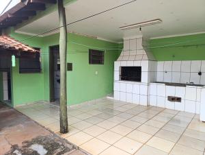 a kitchen with green and white walls and a pole at cantinho da paz in Dourados