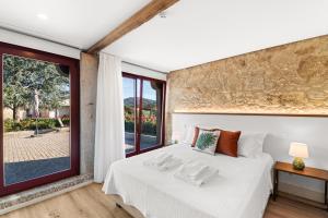 a bedroom with a white bed and a large window at RioVerde Agroturismo in Barcelos +69 photos