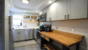 a kitchen with white cabinets and a wooden counter top at Valley View 4 Campton White Mountain Condo With Views in Campton