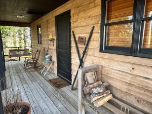 eine Veranda an einer Holzhütte mit einer Tür in der Unterkunft Fire Mountain in Highlands